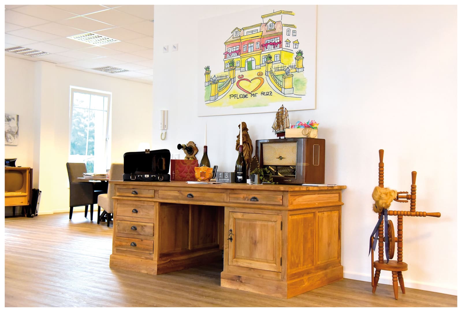 Dienstzimmer des Pflegedienstes mit Schreibtisch und gerahmtem Bild an der Wand